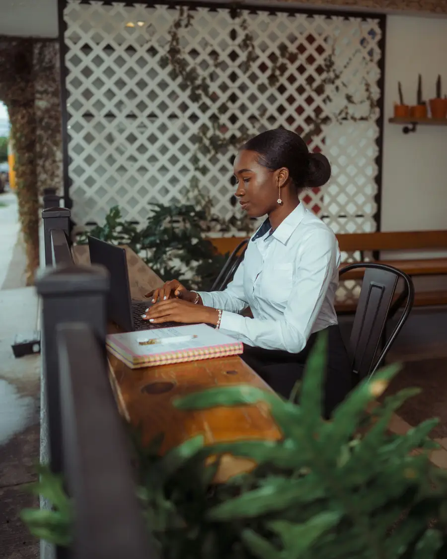 An accountant working through figures with a laptop and a notebook