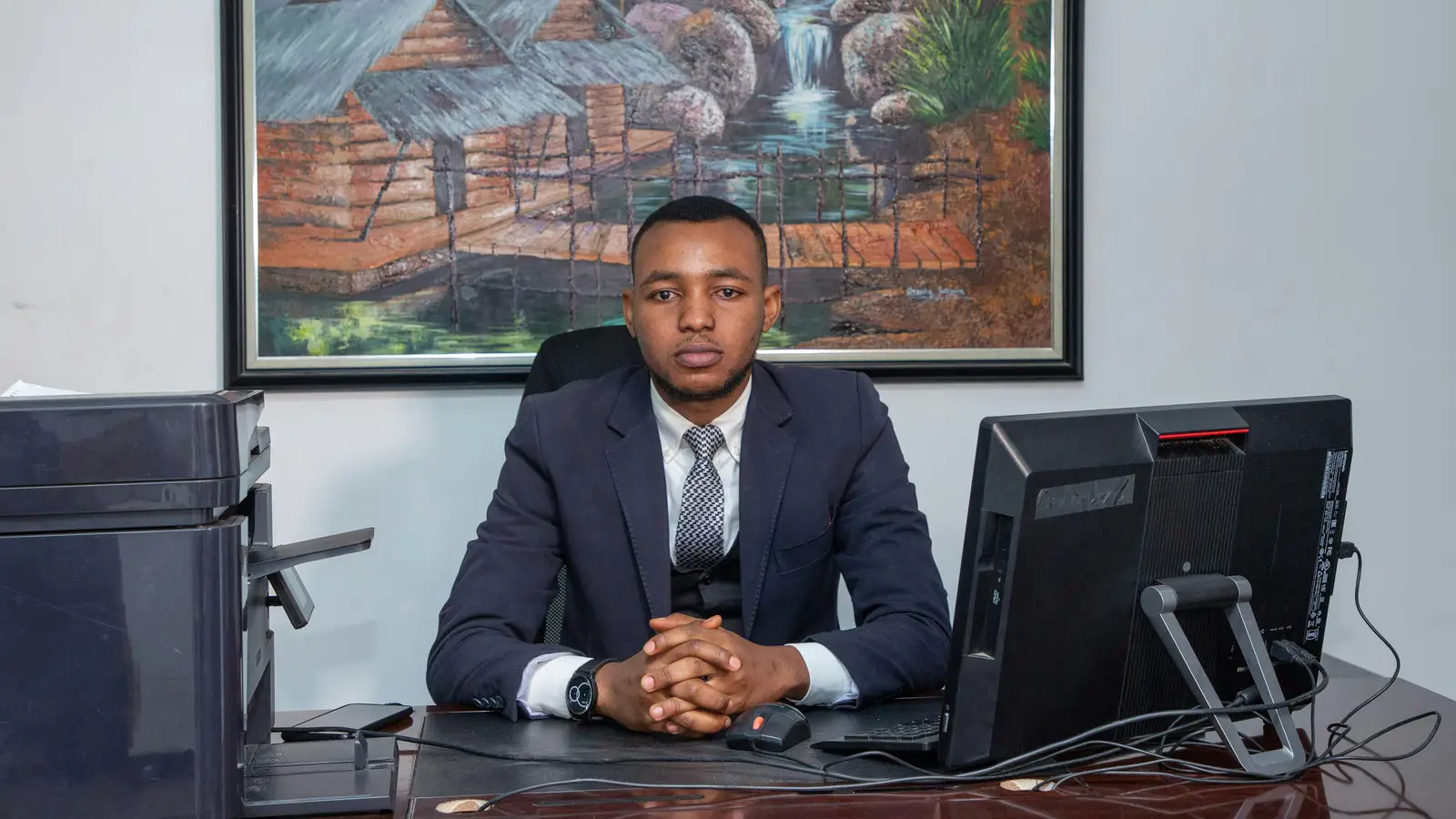 An accountant at a desk in an office, with a monitor and printer alongside