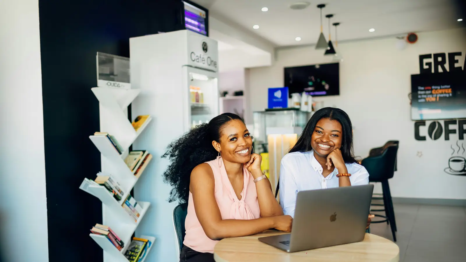 Two business owners reviewing work together on a laptop in a Lagos café